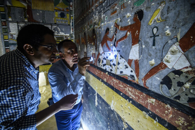 TOPSHOT – Mohamed Mujahid (L), head of the Egyptian mission which discovered the tomb of the ancient Egyptian nobleman “Khewi” dating back to the 5th dynasty (24942345 BC), inspects the tomb’s walls inside at the Saqqara necropolis, about 35 kilometres south of the capital Cairo on April 13, 2019. (Photo by Mohamed el-Shahed / AFP)        (Photo credit should read MOHAMED EL-SHAHED/AFP/Getty Images)